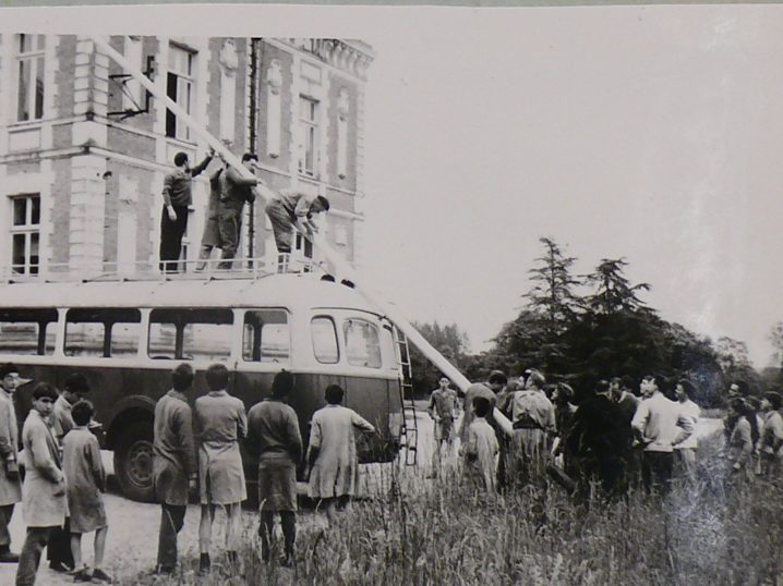 L'illustration comporte une photographie d'un album photo. On retrouve le titre : « 7 mai 1961 : Première montée des couleurs. » Il suit deux photographie montrant des personnes en train de monter le drapeau.