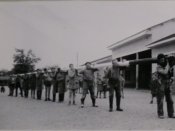 L'illustration comporte une photographie d'un album photo. On retrouve le titre : « 7 mai 1961 : Première montée des couleurs. » Il suit deux photographie montrant des personnes en train de monter le drapeau.